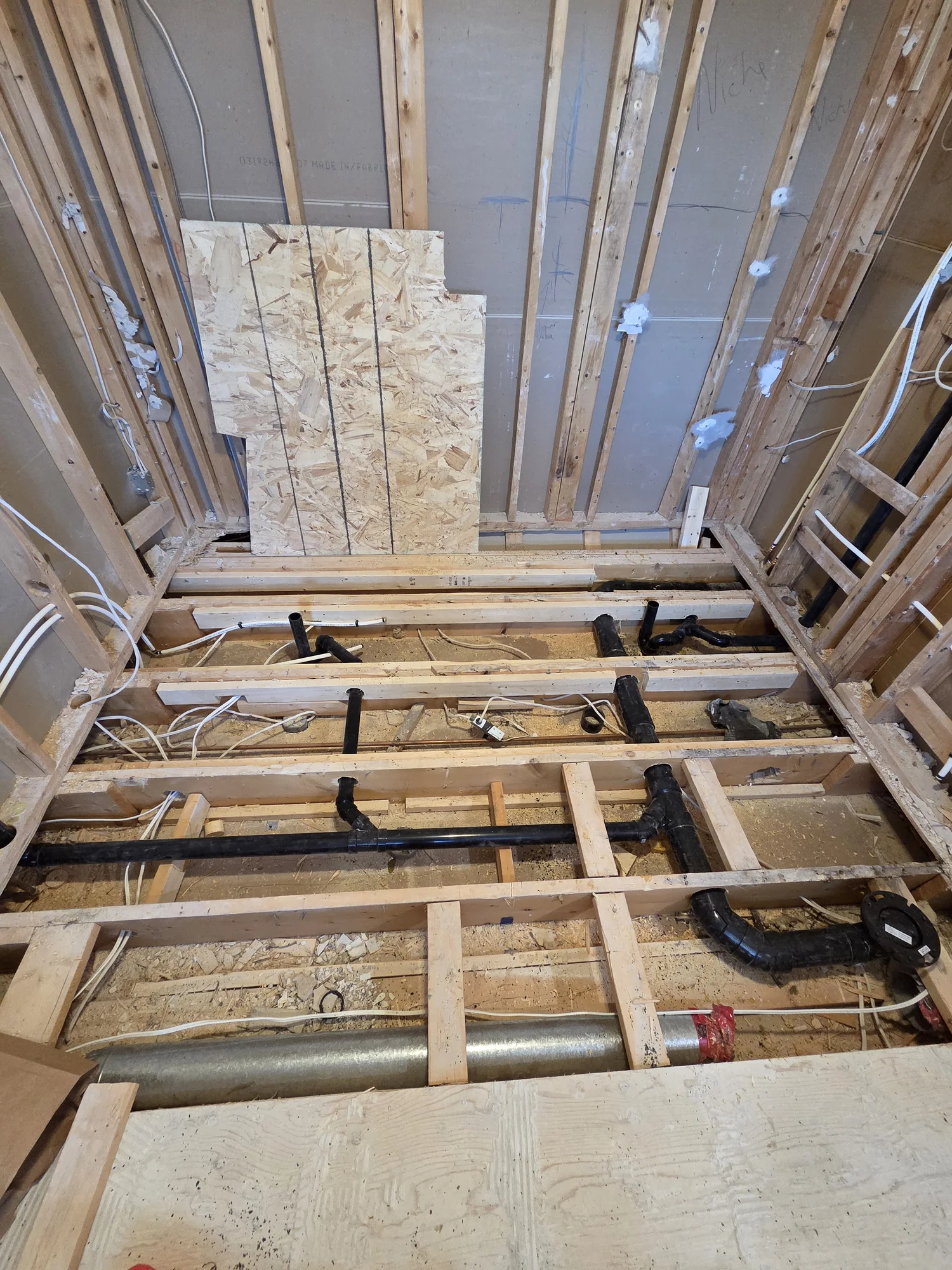 Bathroom drain and PEX supply lines beneath an open floor