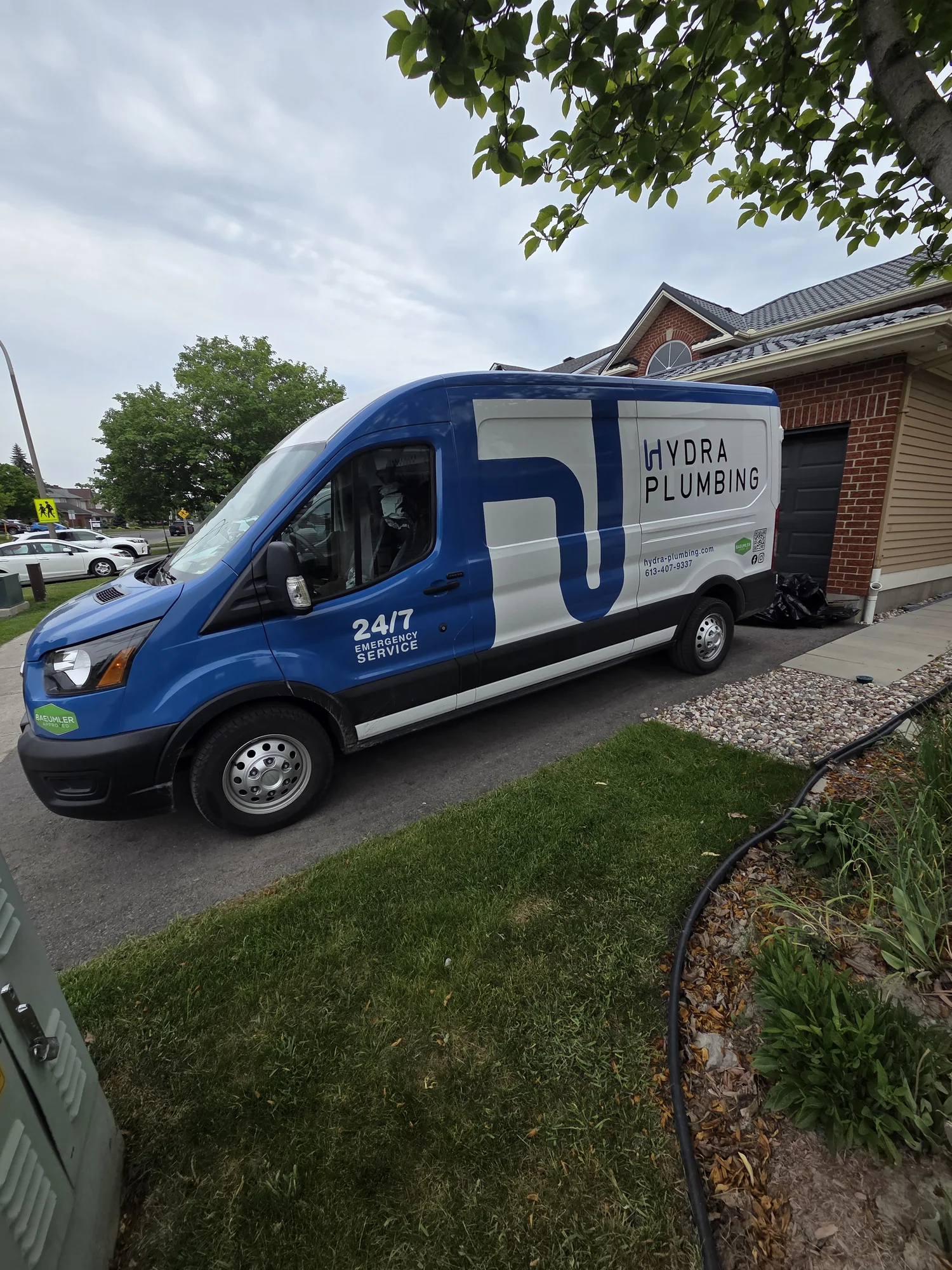 Blue Hydra Plumbing service van parked beside a home