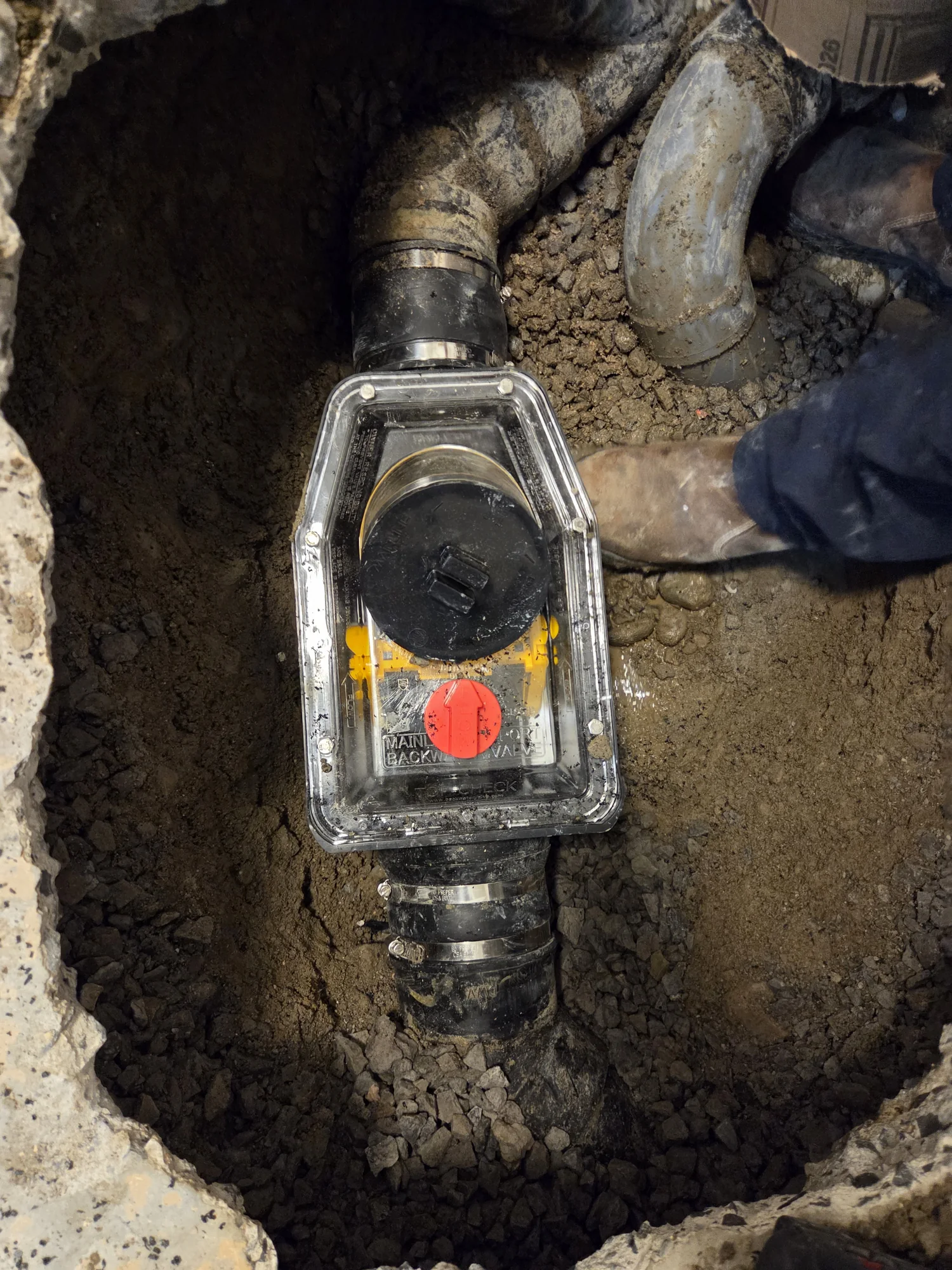 Clear-cover backwater valve connected to a basement sewer pipe