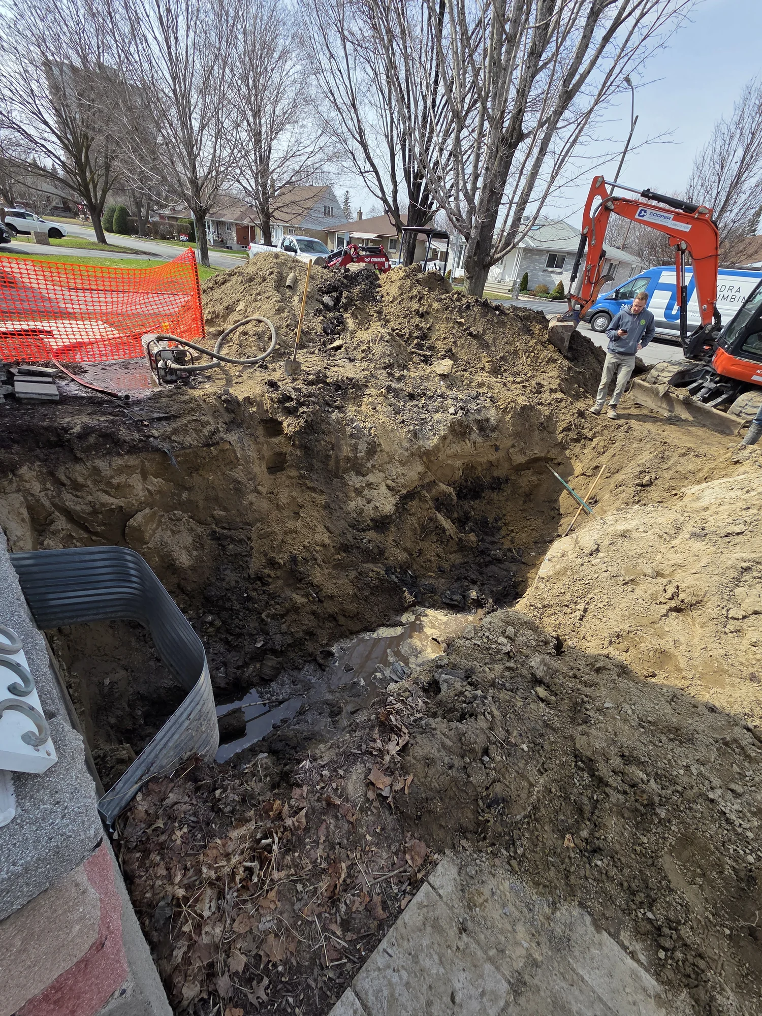 Outdoor plumbing service trench beside a house