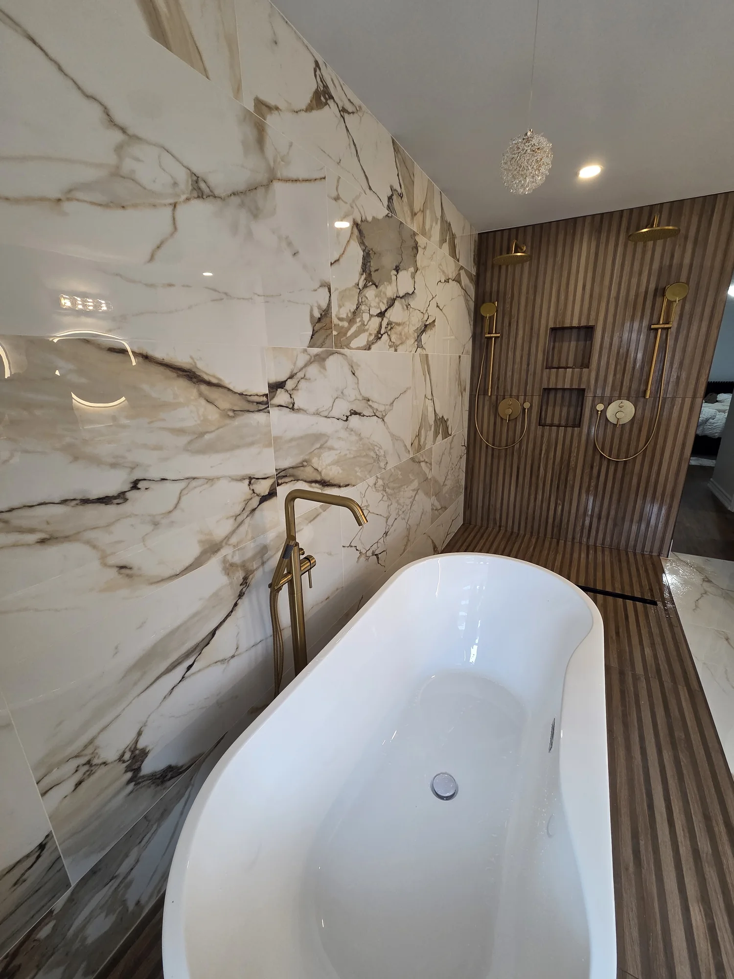 White freestanding tub with a brass floor-mounted faucet