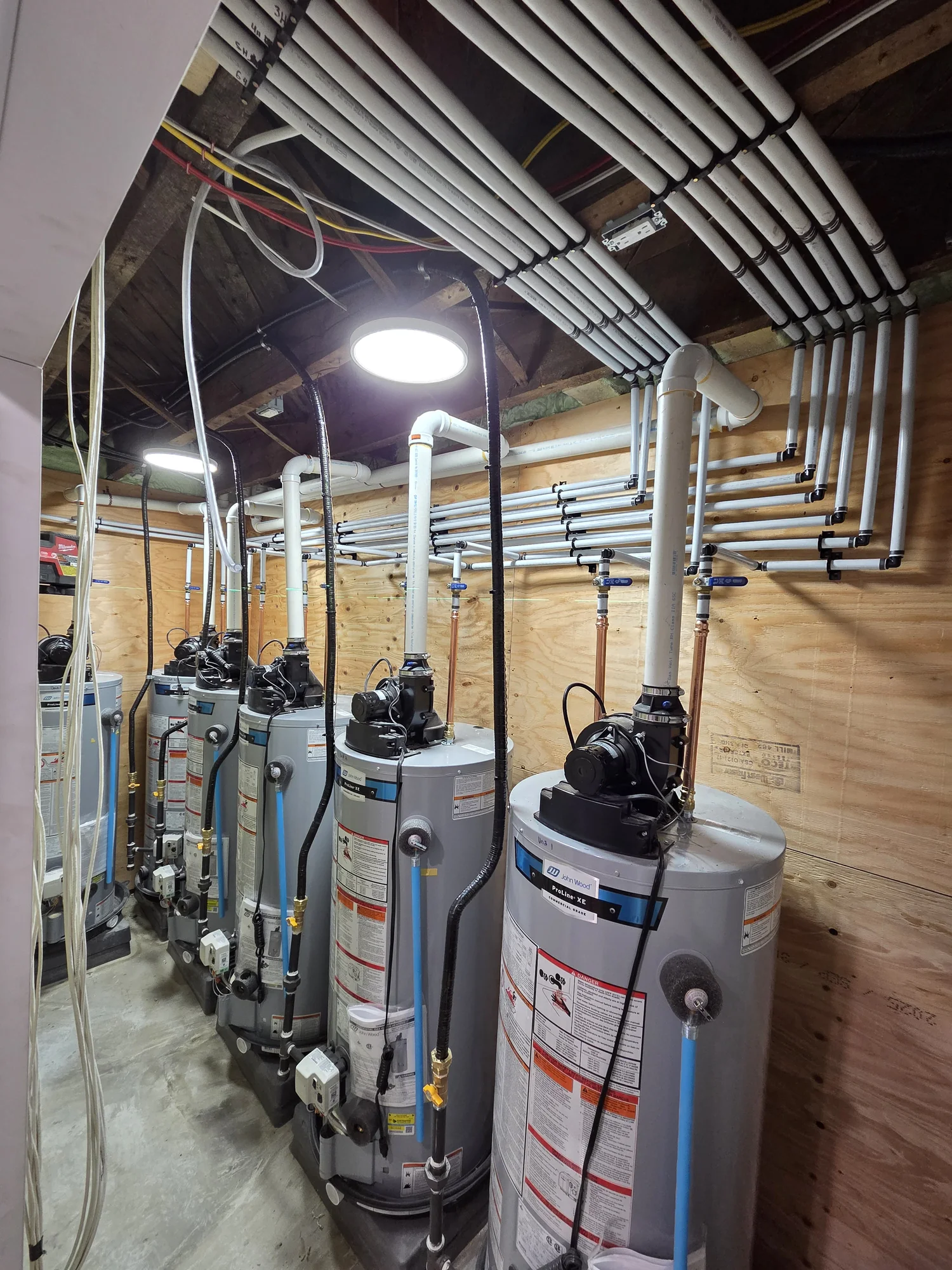 Multiple water heaters and overhead supply manifolds