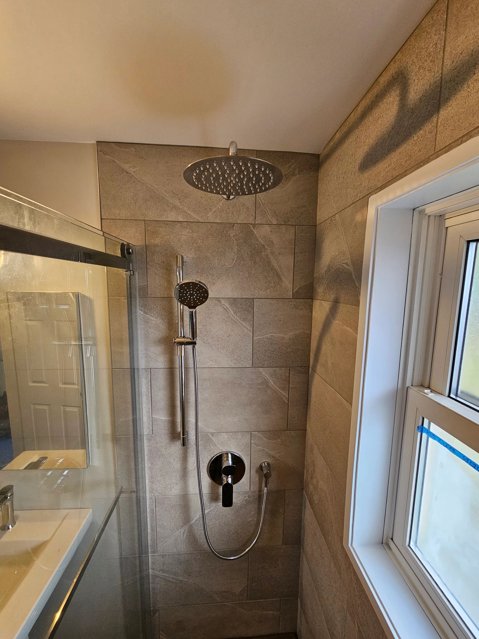 Tiled rain shower with modern plumbing fixtures